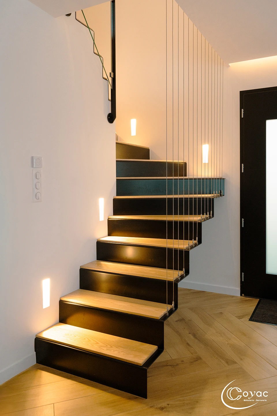 Escalier sur-mesure métal et bois au design aérien à Savenay, avec marches pliées en chêne, garde-corps à câbles inox et éclairage d'ambiance, fabriqué par Coyac