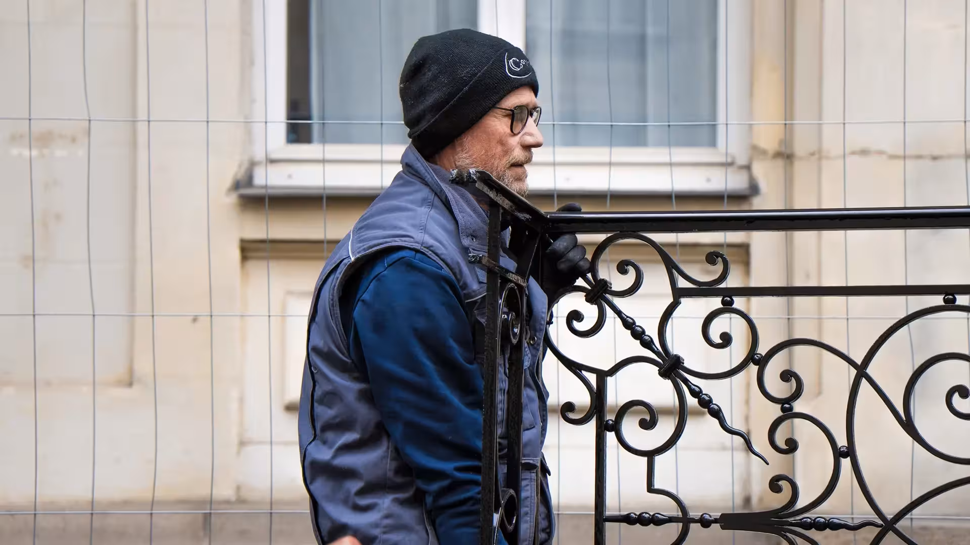 Compagnon ferronnier de Coyac manipulant un garde-corps en fer forgé restauré sur le chantier de la Banque de France à Nantes