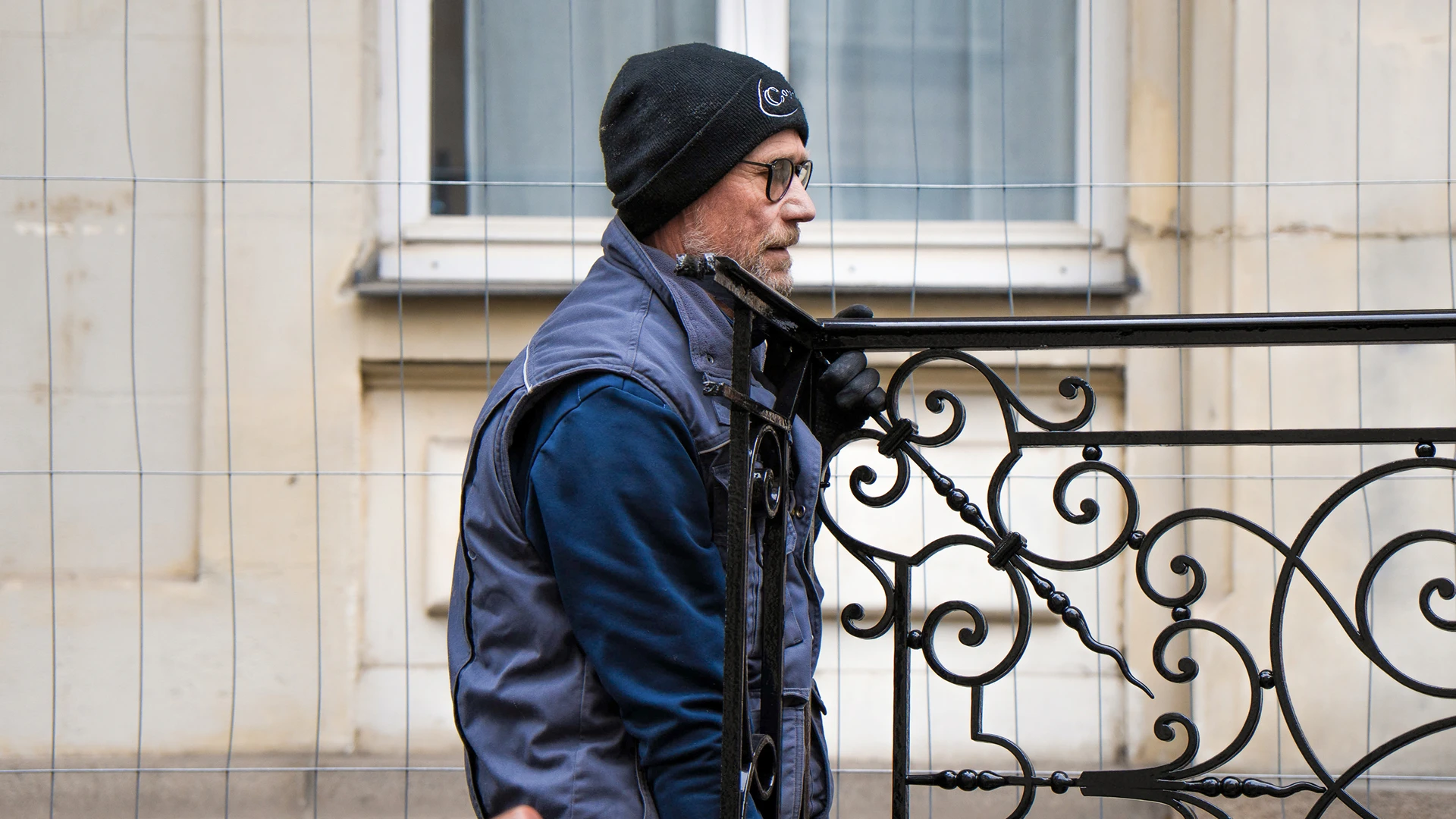 Compagnon ferronnier de Coyac manipulant un garde-corps en fer forgé restauré sur le chantier de la Banque de France à Nantes