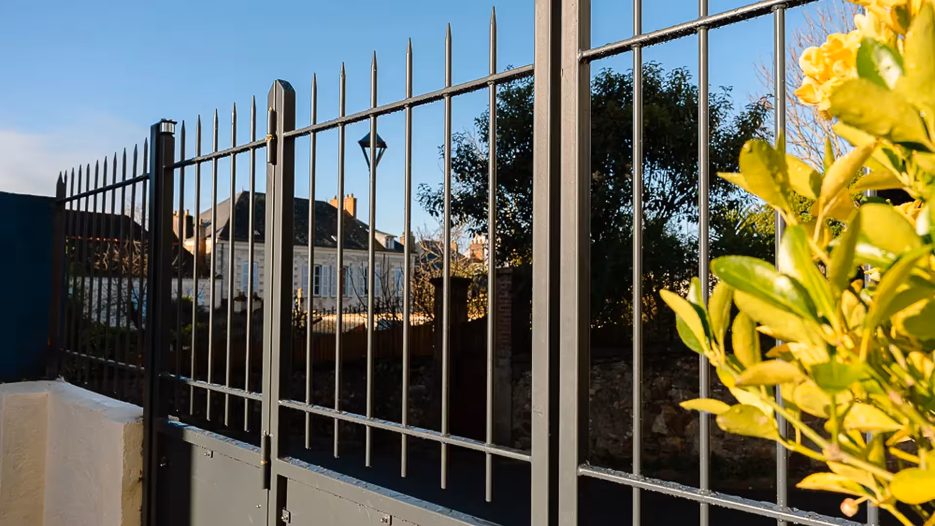 Détail de la clôture à barreaux verticaux et pointes intégrée au portail sur-mesure de Basse Indre, fabriqué par Coyac