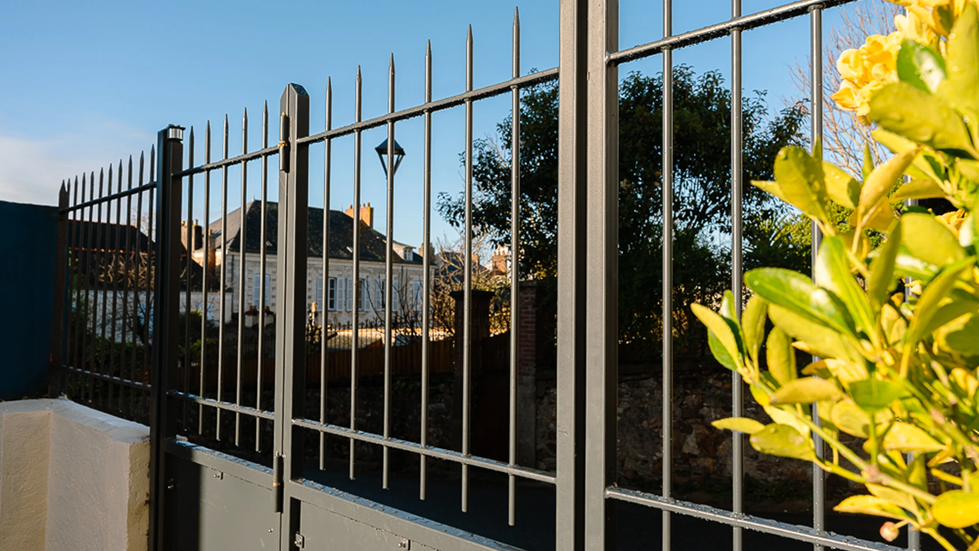 Détail de la clôture à barreaux verticaux et pointes intégrée au portail sur-mesure de Basse Indre, fabriqué par Coyac