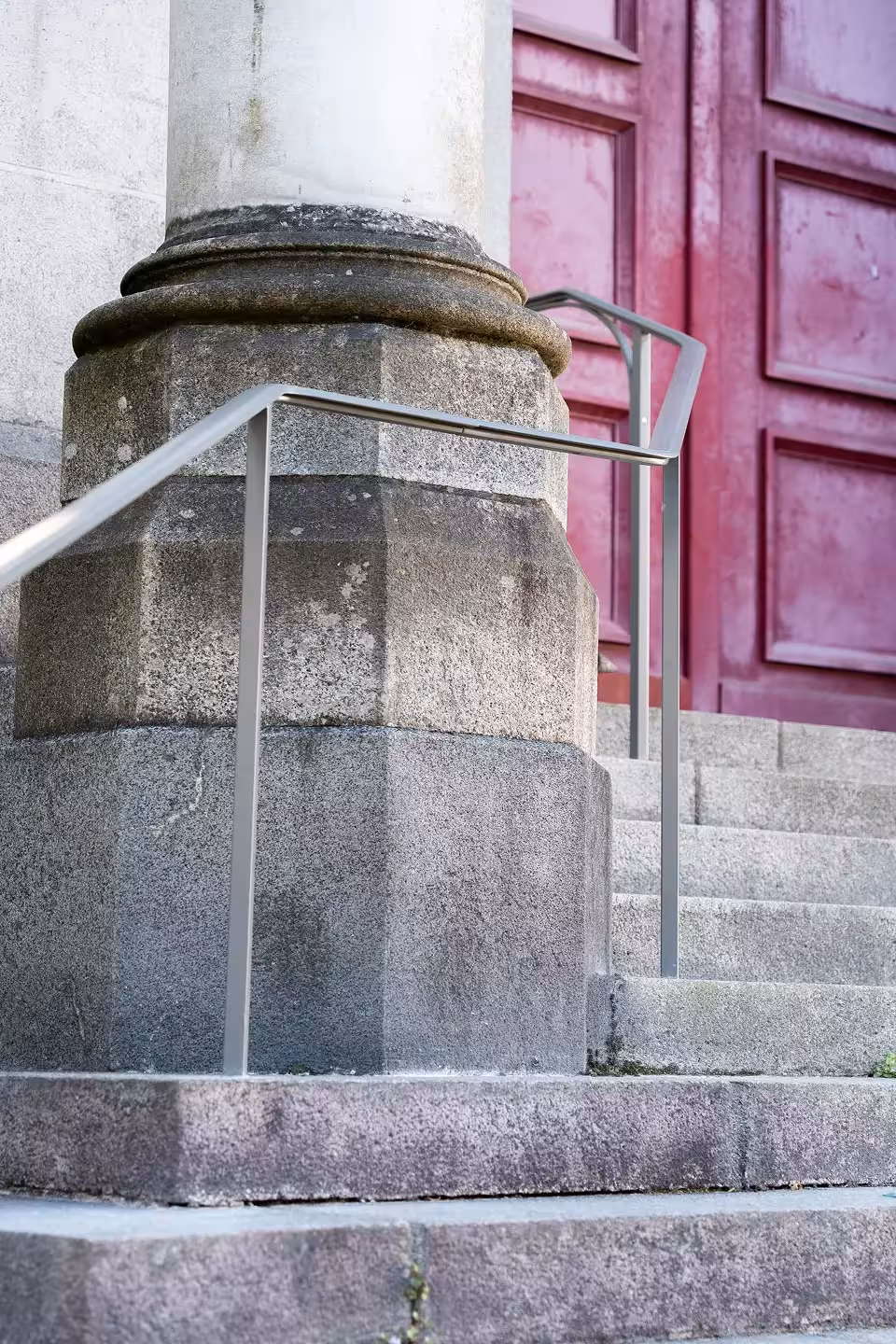 Mains courantes sur-mesure en acier laqué clair posées au pied d'une colonne en granit, devant la porte principale de l'église Notre-Dame de Toute Joie à Nantes