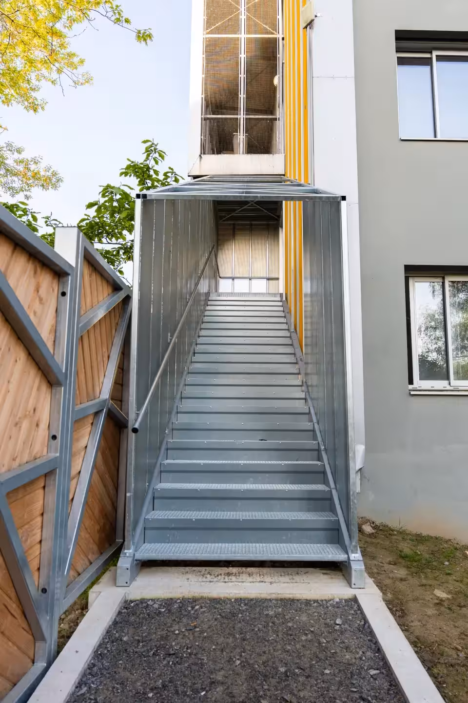 Vue latérale d'une cage d'escalier métallique habillée de tôle perforée au CHU Saint-Jacques de Nantes, fabriquée et posée par Coyac