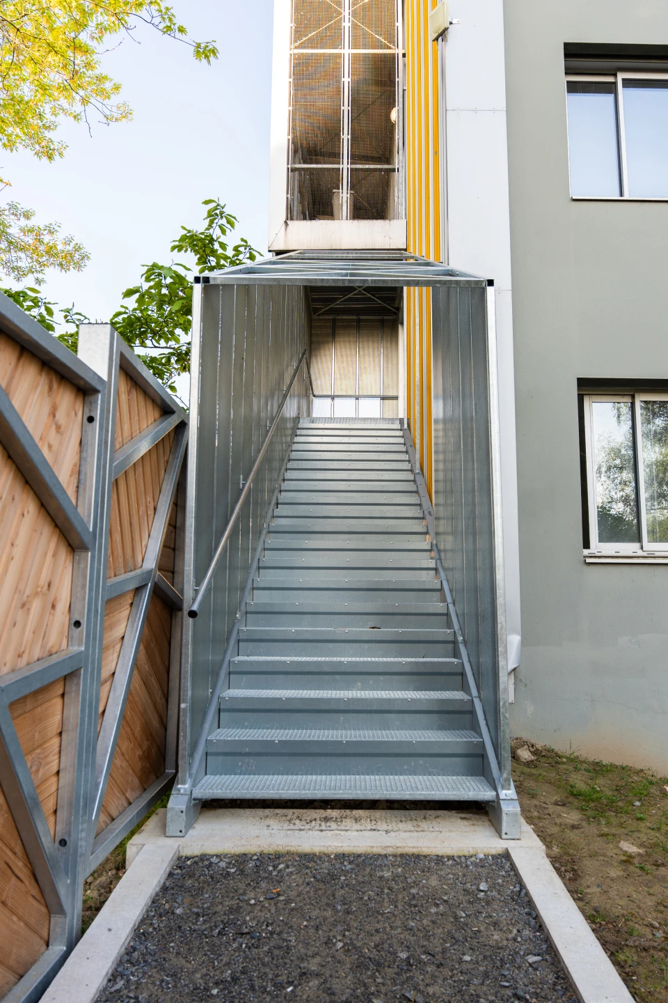 Vue latérale d'une cage d'escalier métallique habillée de tôle perforée au CHU Saint-Jacques de Nantes, fabriquée et posée par Coyac
