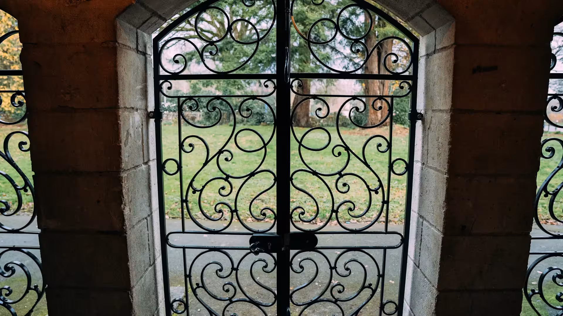 Grille centrale en fer forgé vue depuis l'intérieur, ouvrant sur un parc, ferronnerie traditionnelle Coyac près de la Beaujoire à Nantes