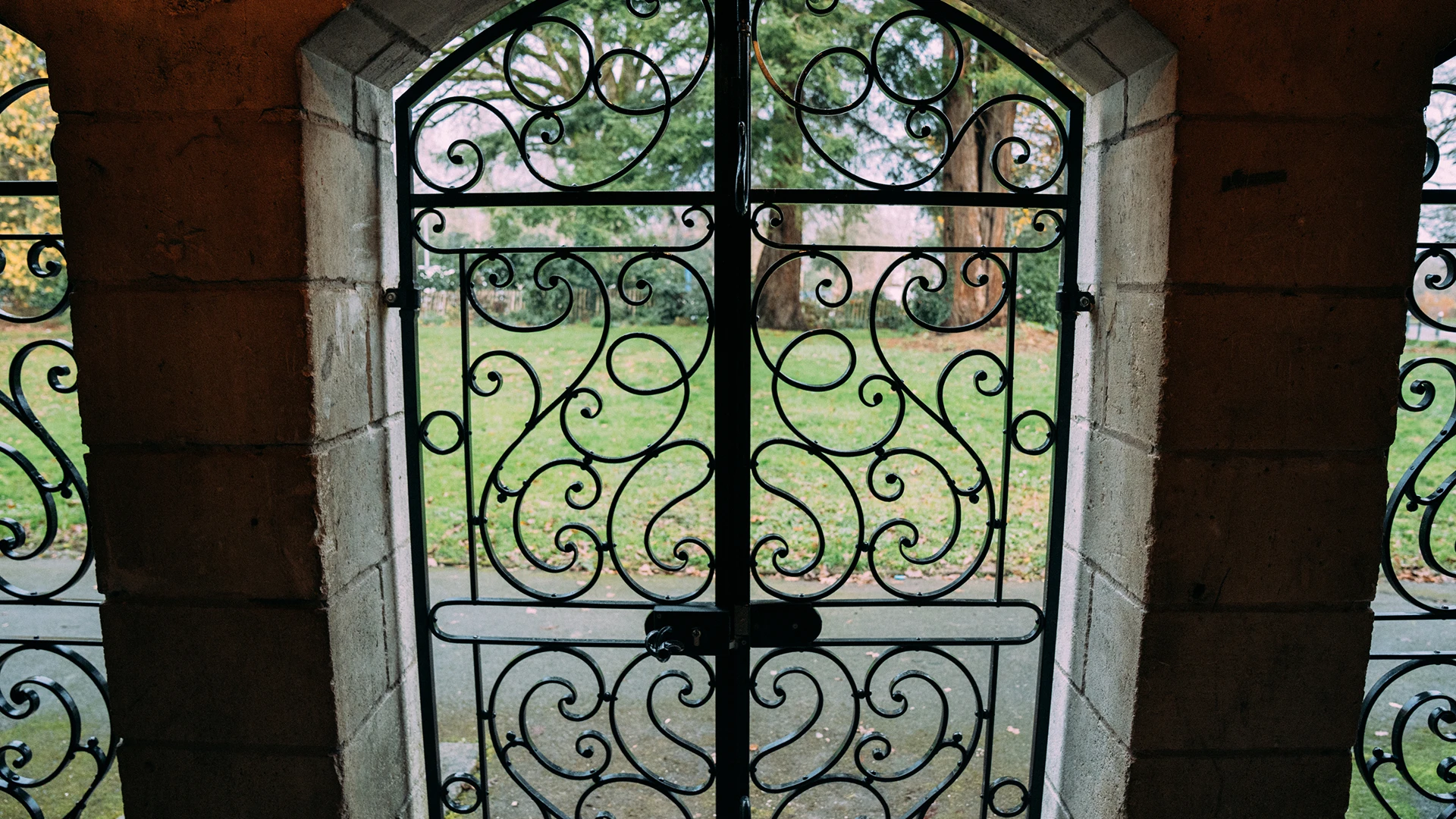 Grille centrale en fer forgé vue depuis l'intérieur, ouvrant sur un parc, ferronnerie traditionnelle Coyac près de la Beaujoire à Nantes